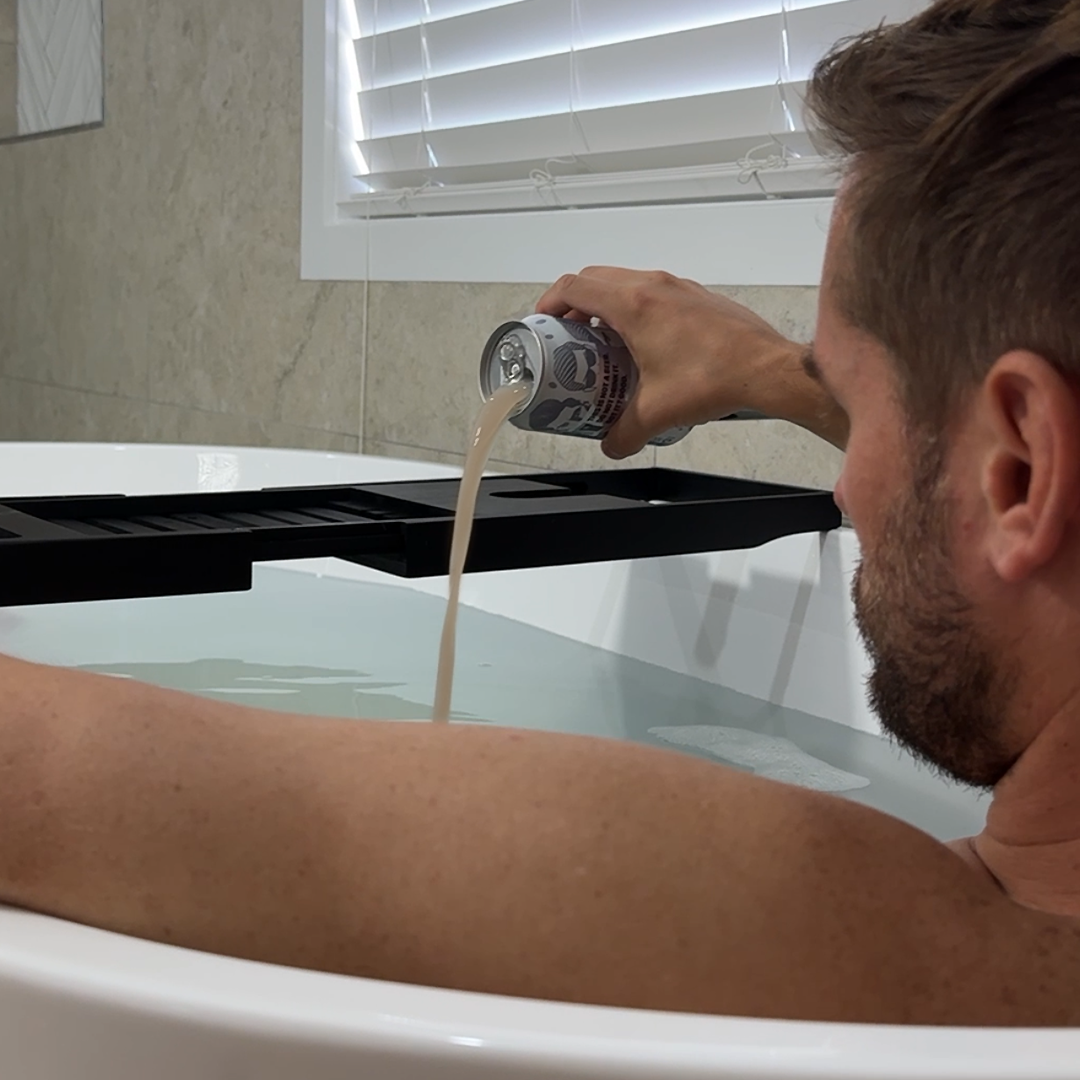 Person pouring a can of The Brew™ into a bathtub filled with water.
